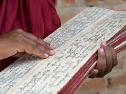 Tibetan monk with sacred Buddhist text